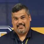 man in polo shirt standing for picture