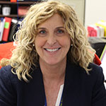 Elizabeth Sproul blonde shoulder-length hair, blue blazer and smiling