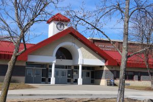 Pine Bush High School brick building with red room and a clock on a rising tower gray doors