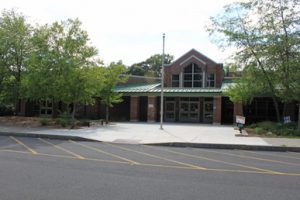 Pine Bush Elementary School brick building wih green roof and trees surrounding it