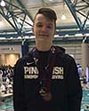 Colin Lang smiles in his Pine Bush Swim team zippered jacket with the pool behind him.