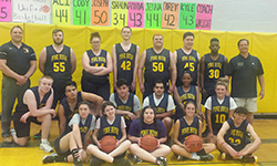 Seventeen members of the Unified Basketball team pose in their blue and gold uniforms along with their coach at right and athletic director at left.