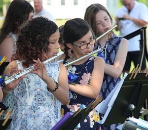 Three girls in the fifth grade band play their flutes