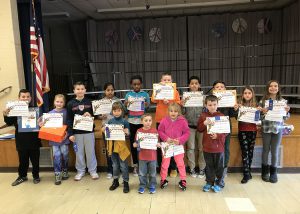 Fourteen elementary students hold up their certificates from their Reflections projects.