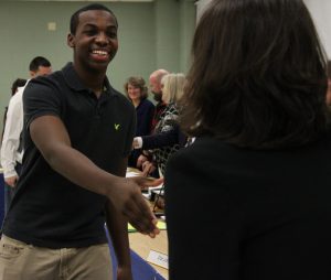 Young man shakes hands with board member