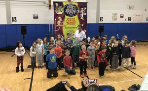 A large group of students pose with the Mad Science instructor
