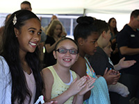 Two smiling girls are clapping for their classmates