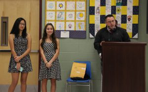 Two young women  listen to coach talk about season