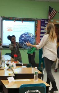 Students hold a large globe showing water on the earth