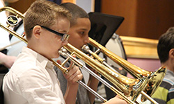Two male students play horns in the band