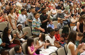 Students stand as their names are announced for awards while others clap for them