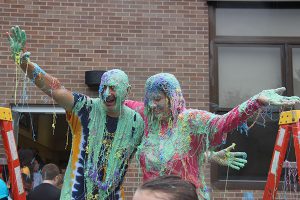 Covered in slime and silly string, the two administrators wave to everyone