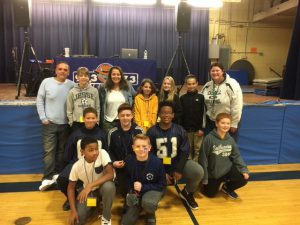 A group of 10 middle school students pose with the hosts of the Wolf radio station along with Assistant Principal Jennifer Lepore