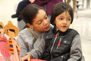 A woman sitting with a young boy on her lap