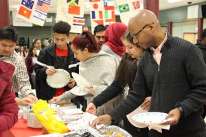 A line of people get food from the table