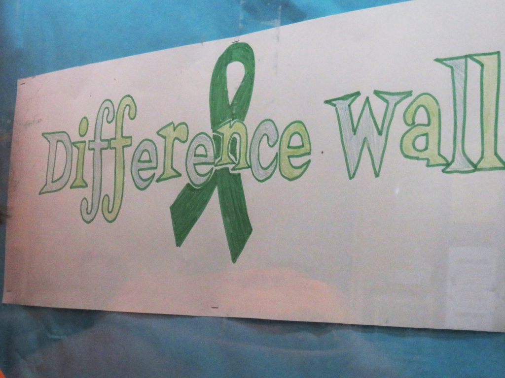 A long poster with the words Difference Wall and a green ribbon