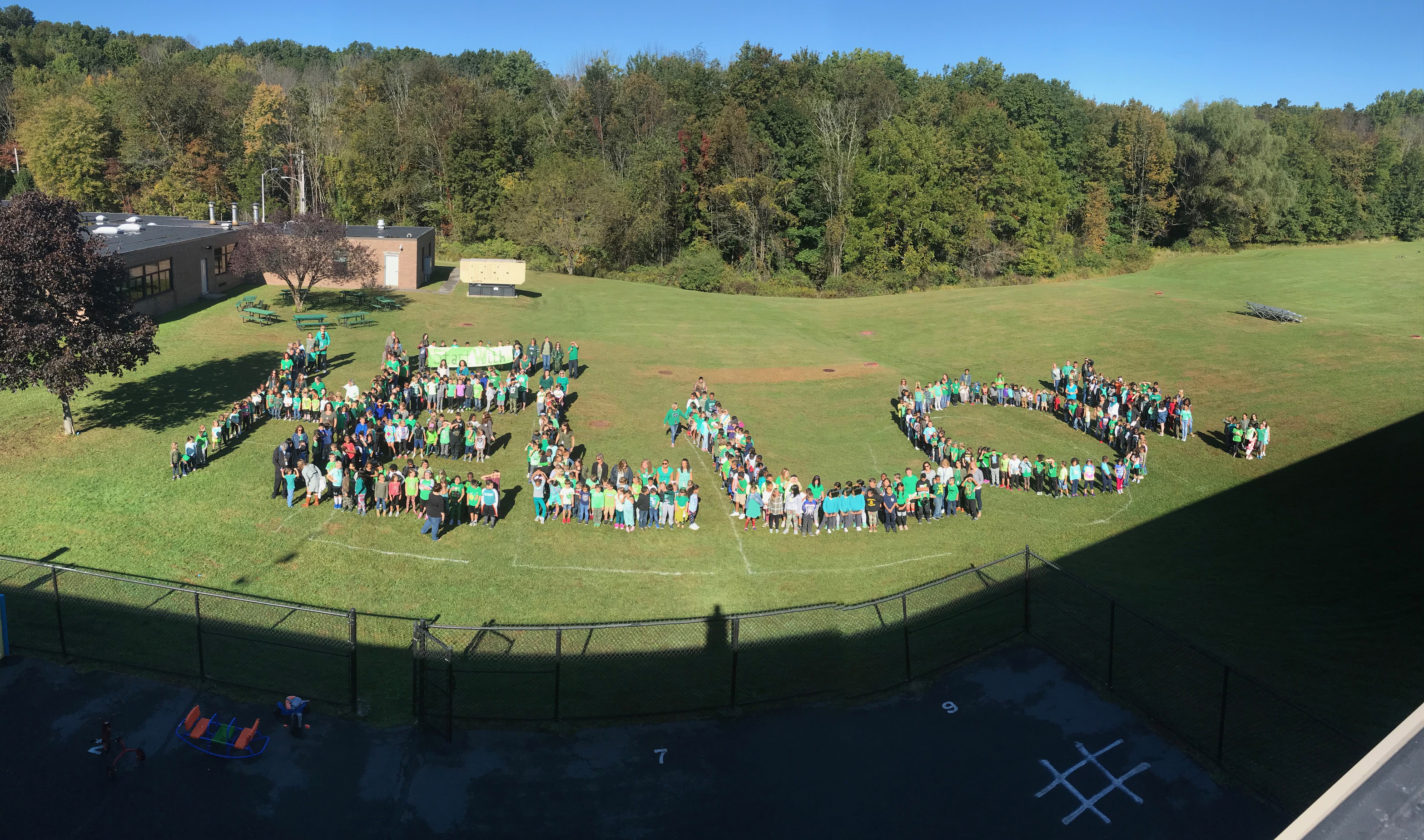 More than 500 students and staff forms the word HELLO! on the field behind the school