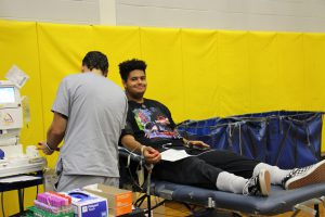 A young man is on a cot donating blood.