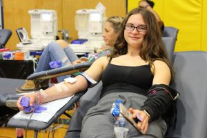 A young woman with glasses is donating blood