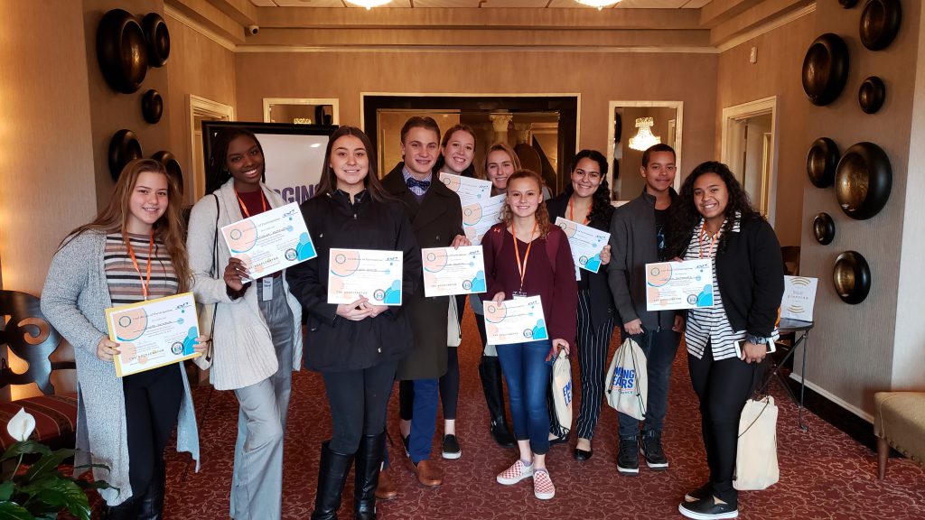 Ten high school students hold certificates and smile