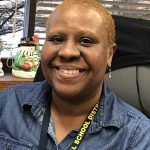 A woman with very short hair smiles