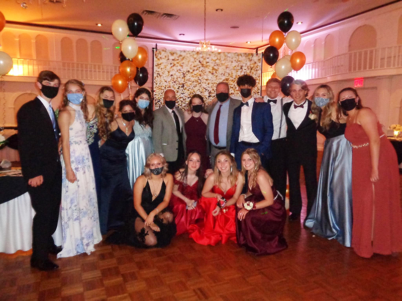 A large group of high school students dressed in tuxes and gowns. 