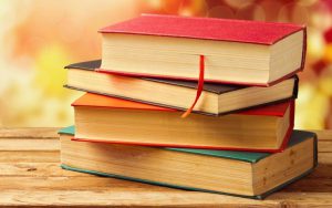 Four hard-covered books in a pile