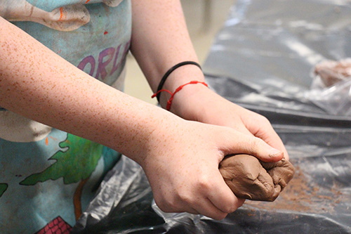 Close up photo of hands molding pottery clay.