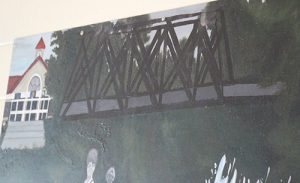 Part of a painted mural showing the front of a school building from the current day and an iron bridge next to it.