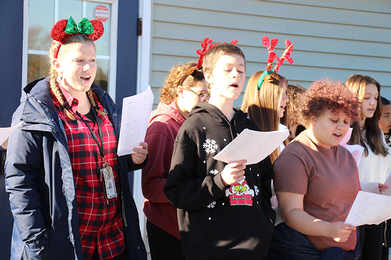 Middle school students sing outside.