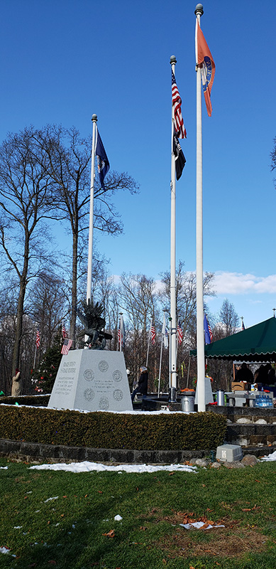 Flags fly at a monument in the cemetery.