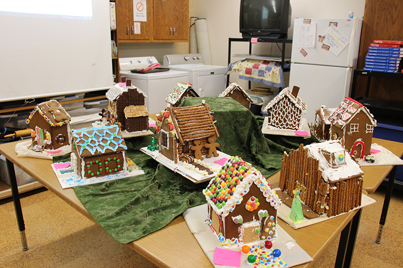 A table filled with several colorful gingerbread houses.