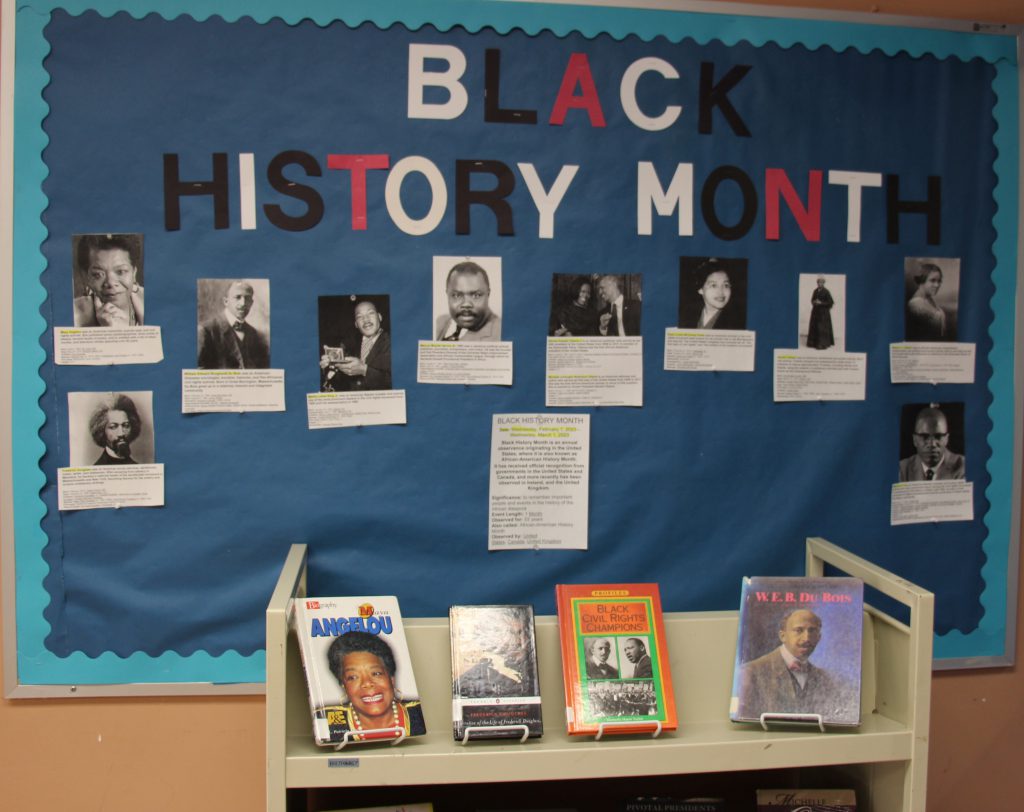 A bulletin board with a blue background that says Black History Month. Beneath the words are pictures and small bios of influential Black Americans.