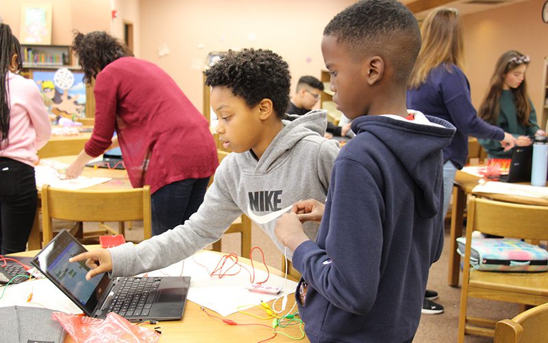 Young woman veteran talks to middle school students about her service