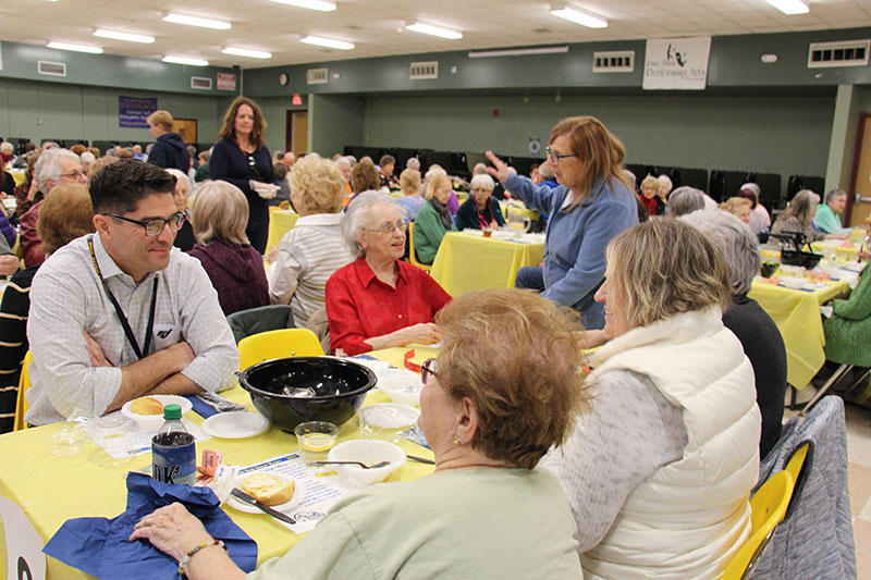 A group of people sit at a table talking.