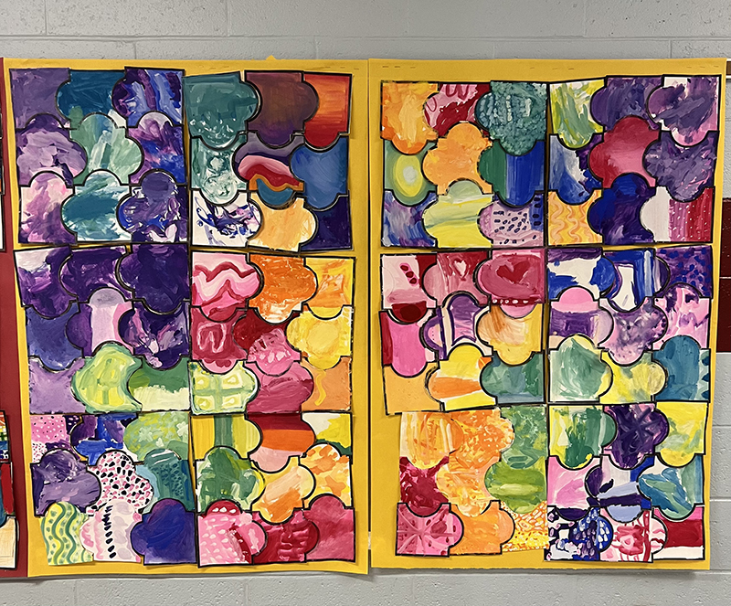 A wall filled with handmade puzzle pieces by elementary students.