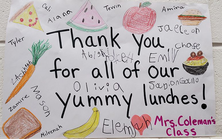 A sign that says Thank you for all of our yummy lunches! There are drawings of many fruits and vegetables and foods on it.