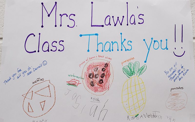 A sign that says Mrs Lawlas Class Thanks you with drawings of food on it.