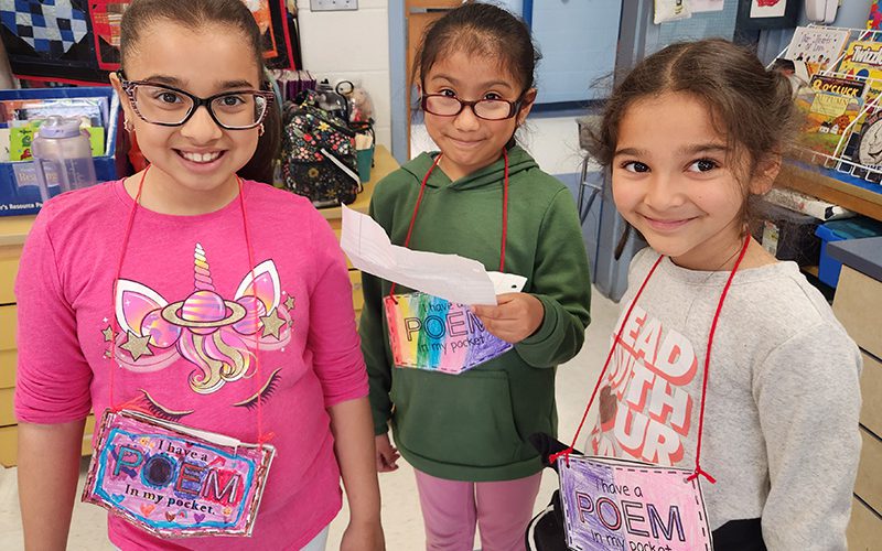 Three girls smiling as they arrive at Pakanasink Elementary School