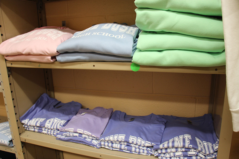 Shelves with pastel colored shirts on them.