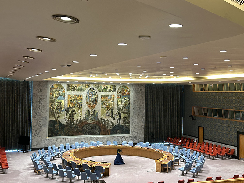 The empty chamber of the United Nations with chairs and desks in a circle.