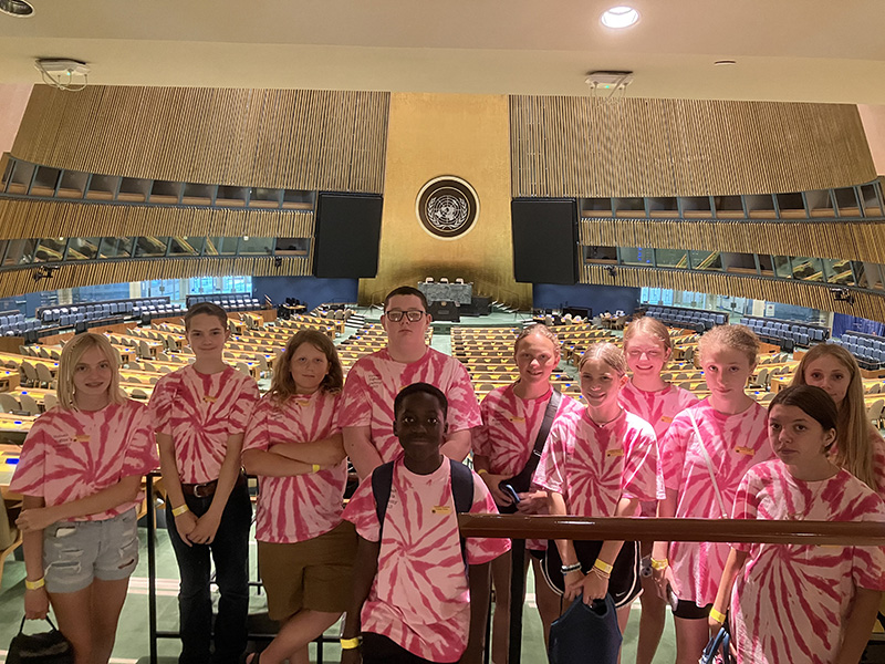 A group of 10 middle school students stand inside the United Nations.