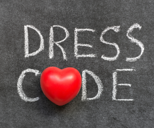 a blackboard background with dress code written in white chalk with a red heart as the o.