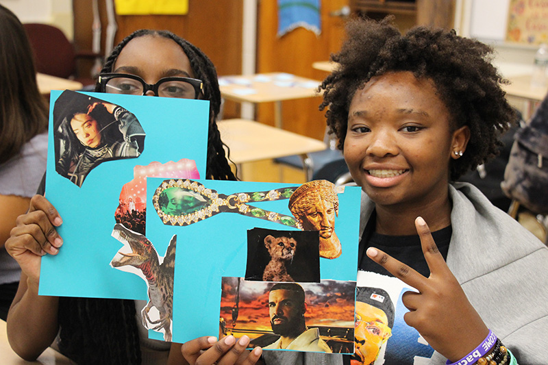 Two high school girls hold up their vision boards, made up of photos they cut out of magazines.