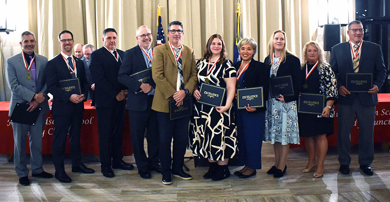 A group of 10 people, all with medals around their necks, holding blue certificates.