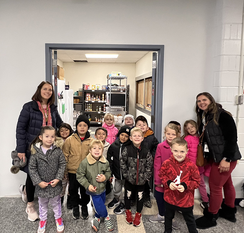 A class of kindergarten students pose with their teachers.