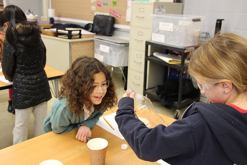 Two third-grade girls work together on a science project.