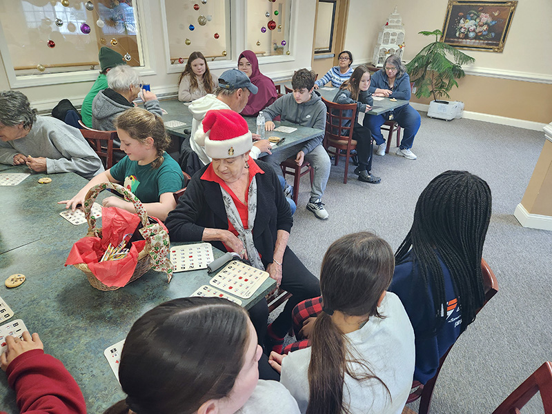 Middle school kids and senior citizens play bingo.