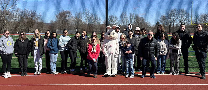 A large group of high school students and adults, along with someone dressed as the Easter Bunny.
