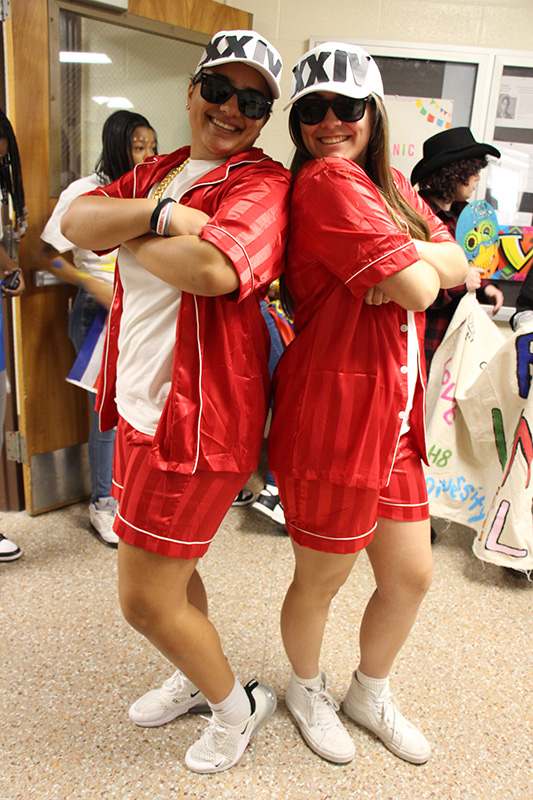 Two high school students dressed in red with white caps, like Bruno Mars.